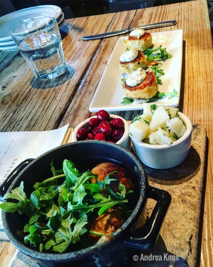 Swed-ish meatballs with cranberry and potatoes in the foreground; crab cakes in the background at Malibu Farm Restaurant